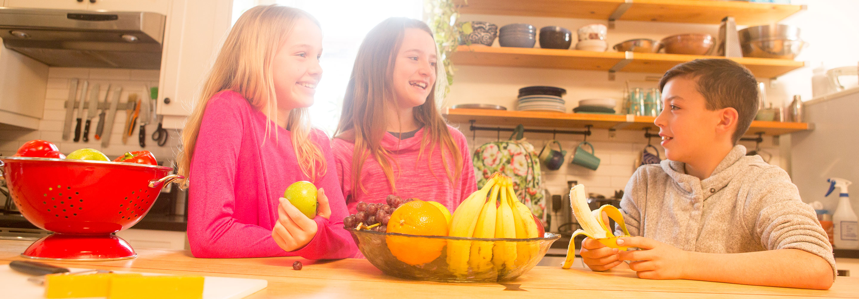 Three youth talking and eating fruit